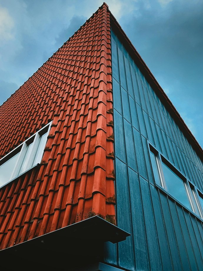 Vértice técnico de Europa 9 que contrasta teja cerámica con cerramientos metálicos.